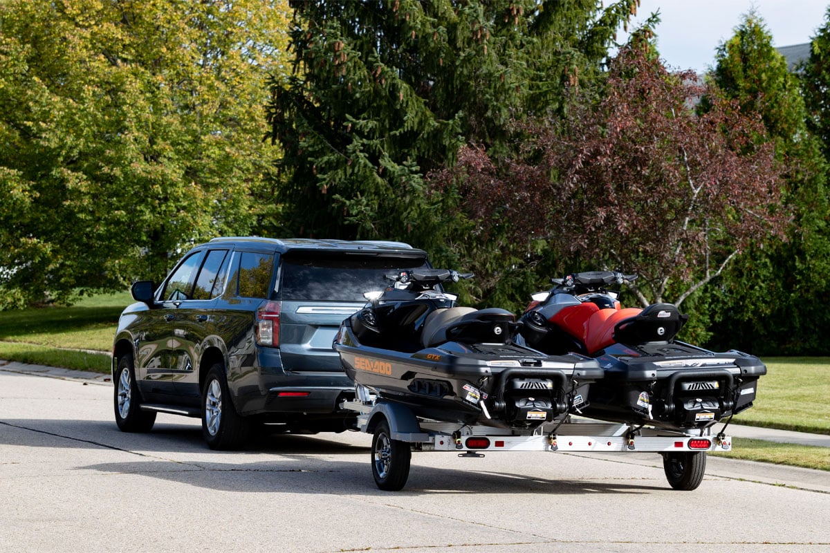 Gray Car Hauling Two Jet Skis With Open Triton Elite Series